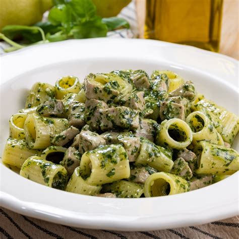 Piatto finito di pasta con pesto e tonno, guarnito con basilico fresco