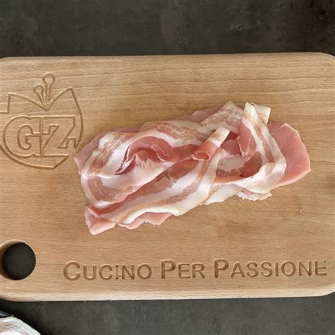 Pancetta di vitello rosolata in padella, servita con contorno di verdure.