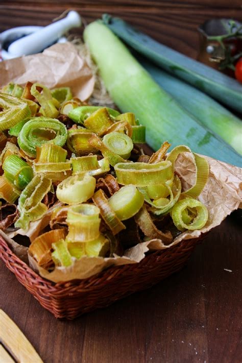 Piatto di tagliatelle cremose con porri, guarnite con chips croccanti di porro e erbe aromatiche