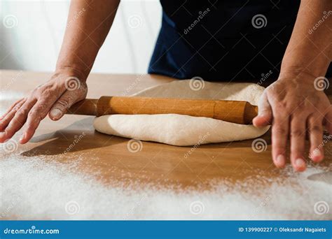 Primo piano di mani che impastano il çiğ köfte con bulgur e spezie