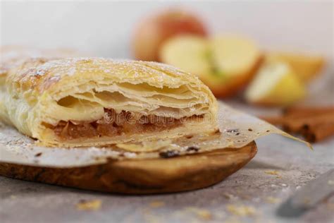 Un primo piano di un rotolo di pasta strudel sottile steso su un tavolo.