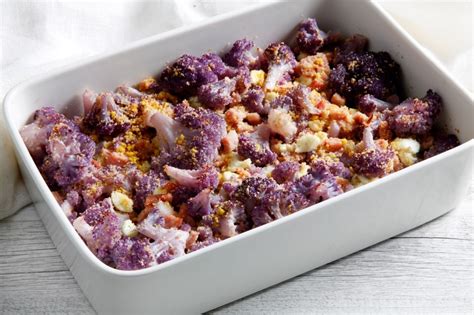 Immagine di un piatto di pennette con cavolfiore viola e pane grattugiato tostato.