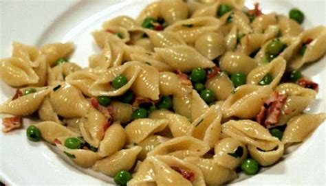Un piatto di pasta e piselli colorato e invitante, con aggiunta di pancetta croccante.