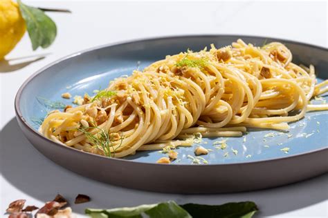 Piatto di spaghetti con colatura di alici, guarnito con scorza di limone e prezzemolo