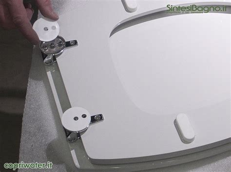 Schema di montaggio del copriwater Koala, con frecce che indicano i punti di fissaggio