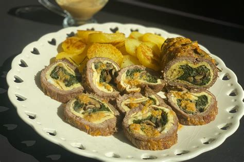Un assortimento di zucchine pronte per essere riempite, con il ripieno di carne a lato.
