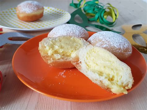 Bomboloni farciti con crema pasticcera e spolverati di zucchero a velo