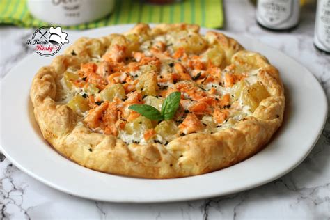 Una torta salata dorata e invitante, con il ripieno di patate e salmone visibile dai bordi.
