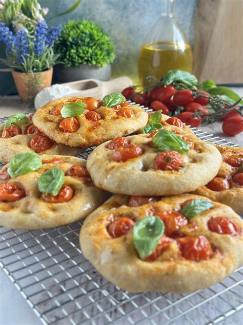 Immagine di focaccine integrali con pomodorini disposti in modo appetitoso su una teglia.