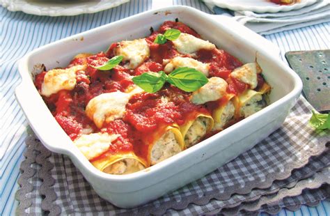 Immagine di cannelloni alla Sorrentina appena sfornati, con formaggio fuso e salsa di pomodoro.