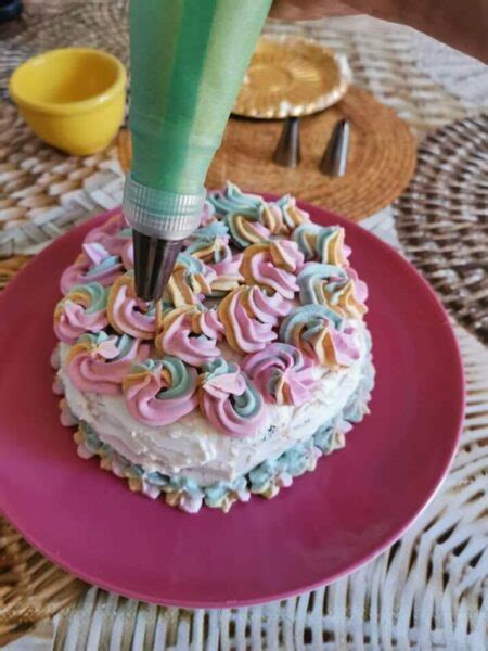 Schema illustrativo dei passaggi per la decorazione della torta unicorno con diverse creme colorate.