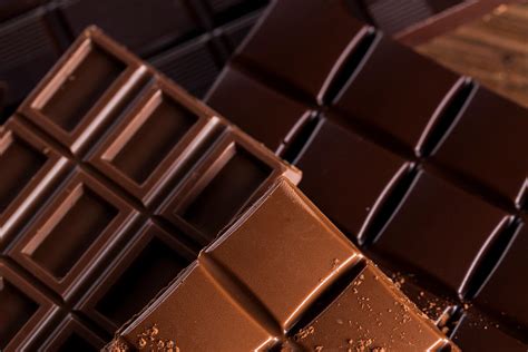 Illustrazione che mostra la differenza tra cioccolato al latte e cioccolato fondente, evidenziando la maggiore percentuale di cacao nel fondente.