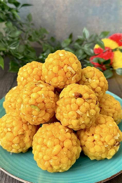 Immagine di Boondi Ladoo finiti, rotondi e dorati, guarniti con pistacchi.