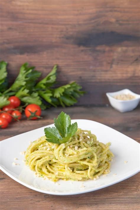 Piatto finito di spaghetti al pesto di sedano, guarnito con pinoli e pecorino