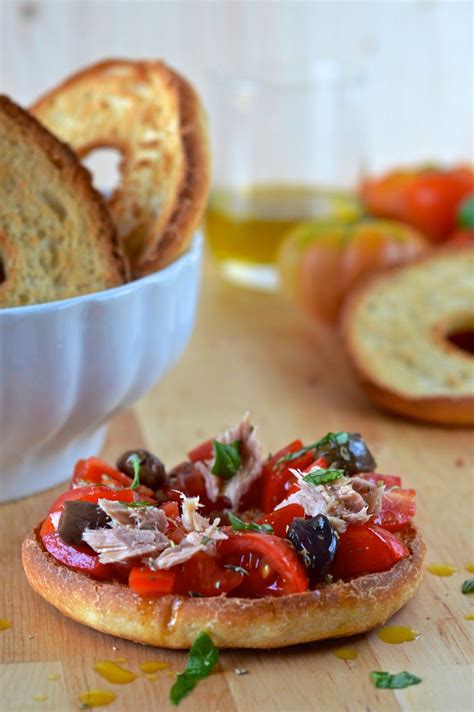 Un primo piano su crostini guarniti con alici, e friselle con tartare di tonno e burrata.