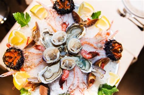Un assortimento di crudi di mare su un letto di ghiaccio, con ostriche, scampi e tartare.