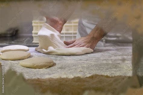 Un pizzaiolo esperto mentre stende l'impasto per una pizza