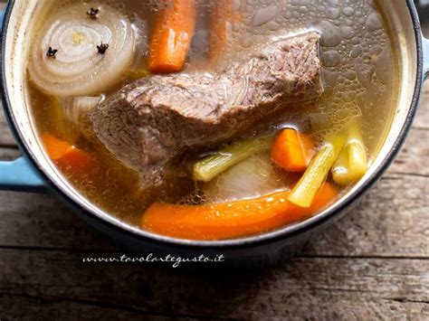 Pentola con brodo di carne e salsiccia in cottura a fuoco lento