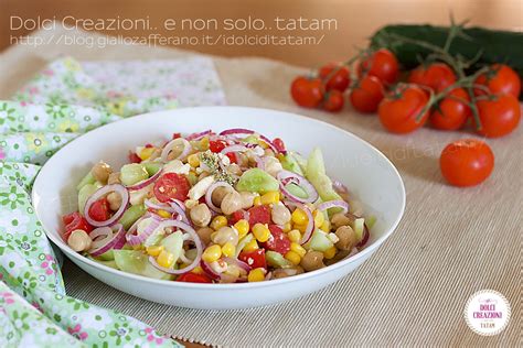 Ingredienti freschi per l'insalata di ceci estiva: ceci, cetrioli, cipolla rossa, mais, pomodorini, mozzarella, erbe aromatiche.
