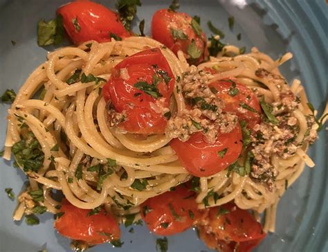 Primo piano di spaghetti conditi con pomodorini marinati