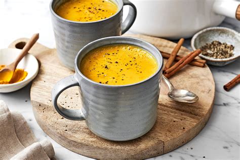 Immagine di una tazza fumante di golden milk con curcuma e spezie.