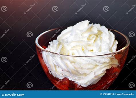Immagine di una ciotola con panna fresca montata e una sac à poche per decorazioni