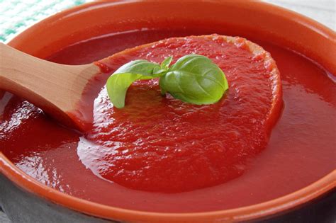 Immagine di vasetti di passata di pomodoro disposti in una pentola per la pastorizzazione