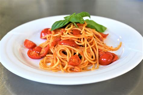 Piatto di spaghetti con sugo di fiori di aglione e pomodorini