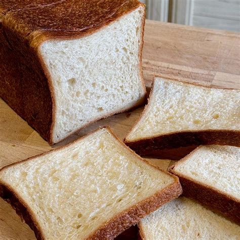 Immagine di un pane in cassetta dorato e invitante, pronto per essere affettato.