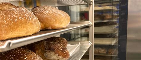 Pane in cassetta appena sfornato, dorato e soffice, posizionato su una griglia per il raffreddamento.
