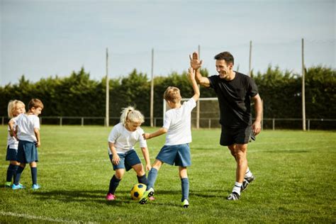 Allenatore di calcio che impartisce istruzioni alla squadra durante l'allenamento