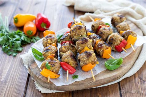 Spiedini di polpette alla paprika affumicata alternati a pomodorini su stecchini di legno.