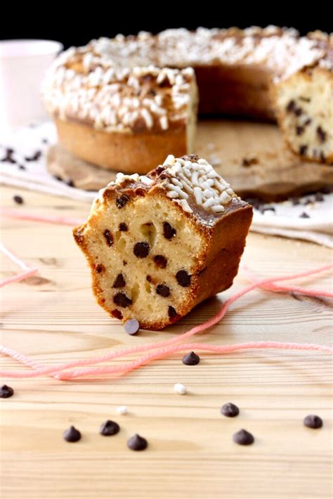 Immagine di un ciambellone allo yogurt, banana, cioccolato e noci appena sfornato, con una fetta tagliata per mostrare l'interno soffice e gli ingredienti mescolati.