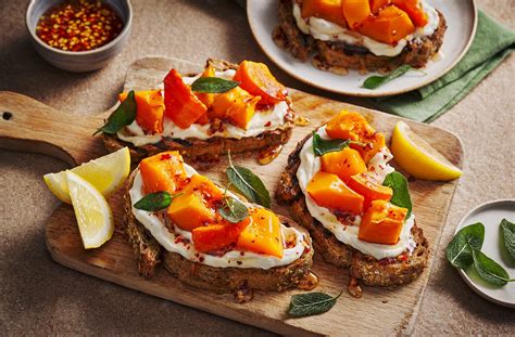 Composizione di bruschette colorate su pane integrale tostato, con diverse guarnizioni.