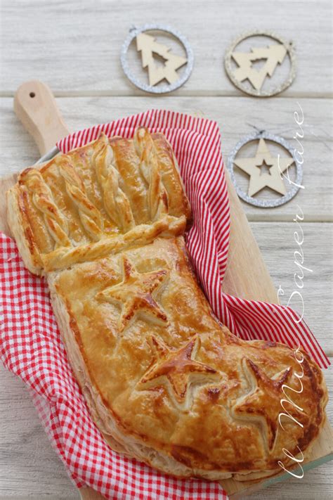 Dettaglio della preparazione della calza della Befana salata: strati di pasta sfoglia, ripieno di salsiccia, salame e scamorza.