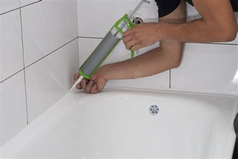 Immagine di un tecnico che applica sigillante siliconico lungo il bordo di una cabina doccia
