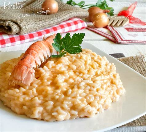 Piatto di risotto alla crema di scampi pronto per essere servito, decorato con scampi e timo