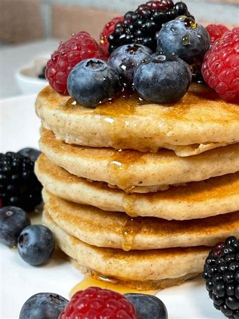 Immagine di pancake vegani finiti, guarniti con frutta fresca e sciroppo d'acero