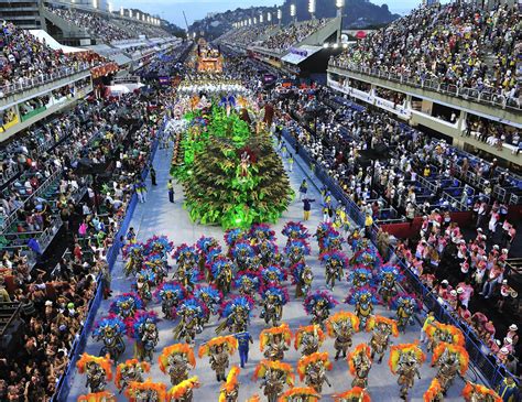 Una sfilata di Carnevale brasiliano con persone che ballano su carri allegorici, con musicisti e percussioni.