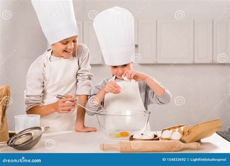 Foto di partecipanti sorridenti che indossano grembiuli e cappelli da chef durante un workshop di cioccolato