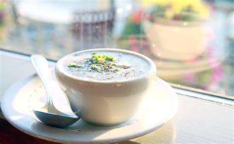 Una ciotola fumante di Clam Chowder cremosa, guarnita con erbe fresche e cracker