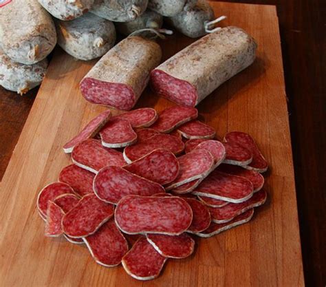 Primo piano di un Salame Aquilano intero, che ne mostri la forma piatta e la grana della carne