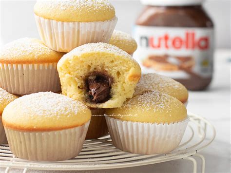 Immagine di muffin alla ricotta e Nutella appena sfornati, con un cuore cremoso di Nutella visibile al taglio.