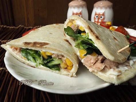 Una piadina aperta e farcita con tonno, pomodoro e mozzarella