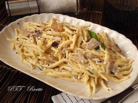 Primo piano di un piatto di trofie con funghi porcini e nduja