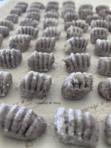 Gnocchi di patate viola appena formati su un vassoio infarinato