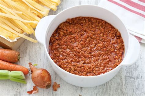 Ingredienti freschi per il ragù alla bolognese: carne macinata, cipolla, carota, sedano, passata di pomodoro