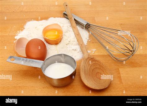 composizione di ingredienti secchi e umidi disposti su un piano di lavoro: farina, uova, olio, zucchero, spezie, marmellata