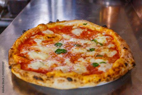 Immagine di una pizza Ristorante appena sfornata, con formaggio filante e ingredienti colorati.