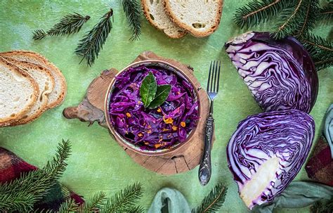 Un campo coltivato con piante di cavolo cappuccio viola in diverse fasi di crescita.